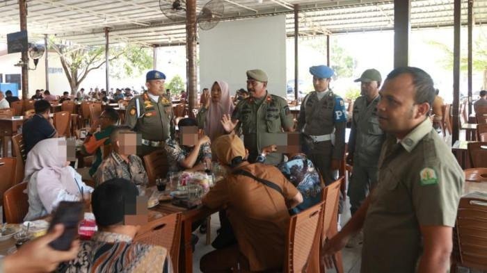 RAZIA KE WARKOP – Petugas Satpol PP-WH Aceh melakukan razia di salah satu warung kopi (warkop) di Kecamatan Ulee Kareng, Banda Aceh, Selasa (16/9/2025), menindak ASN yang kedapatan nongkrong saat jam kerja.

