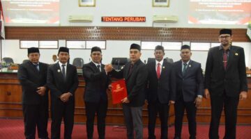 Bupati Muharram Idris bersama pimpinan DPRK memperlihatkan dokumen persetujuan Qanun APBK-P Aceh Besar TA 2025 usai disahkan dalam Sidang Paripurna di Kota Jantho. (Foto/MC Aceh Besar)
