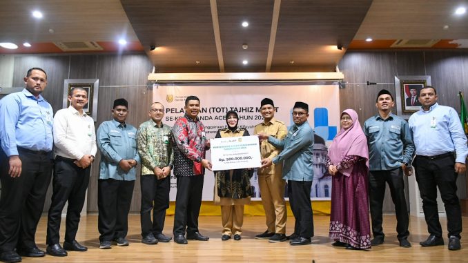 Wali Kota Banda Aceh Illiza Sa’aduddin Djamal menerima simbolis zakat perusahaan PT Bank Aceh Syariah sebesar Rp500 juta dari Kepala KPO Bank Aceh Syariah Andri di Aula Balai Kota Banda Aceh, Selasa (7/10/2025).