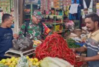 Babinsa Koramil 25/Syi’ah Kuala, Serda Muswandi, saat berdialog dengan pedagang Pasar Rukoh Barona, Banda Aceh, dalam kegiatan pemantauan harga sembako, Minggu (12/10/2025).