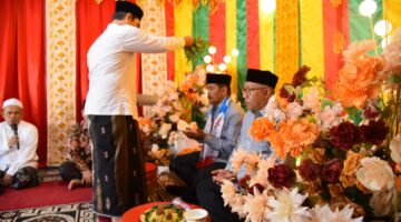 Wakil Bupati Aceh Besar Drs H Syukri A Jalil, bersama Ketua Kafilah Farhan AP, serta rombongan, dipeusijuek pada acara penyambutan Kafilah Aceh Besar, di Pendopo Bupati Pidie Jaya, Kamis (30/10/2025). FOTO/ MC ACEH BESAR