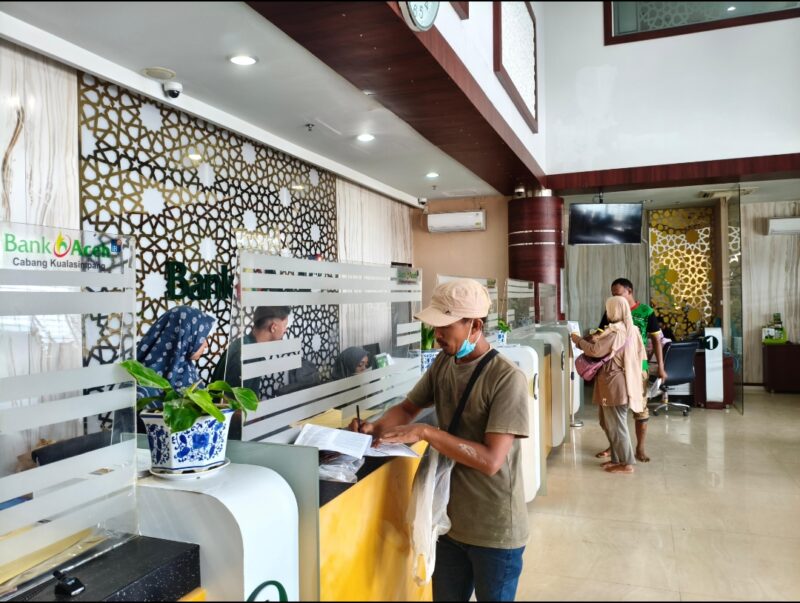 Seorang nasabah Bank Aceh melakukan transaksi di Kantor Cabang Banda Aceh, menandai kembalinya layanan perbankan 100 persen setelah 192 jaringan kantor Bank Aceh pulih penuh pasca banjir di Aceh.